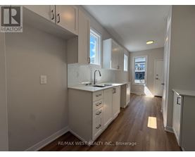A kitchen with white cabinets and a window.