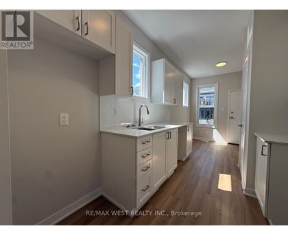 A kitchen with white cabinets and a window.