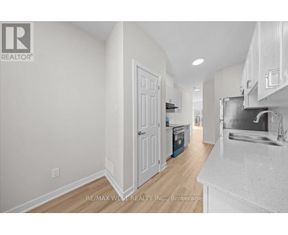 A white kitchen with a sink and a refrigerator.