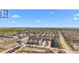 A real estate company logo is displayed on a large image of a housing development.