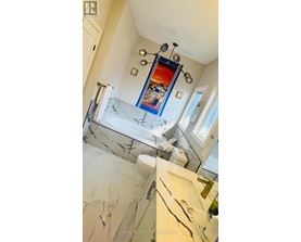 A bathroom with a marble floor and a mirrored wall.
