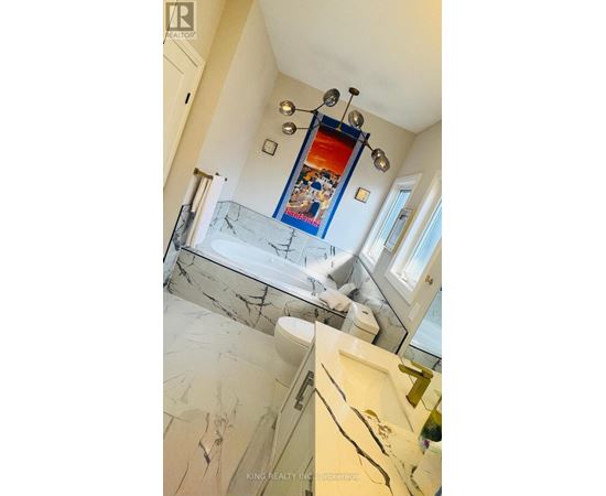 A bathroom with a marble floor and a mirrored wall.