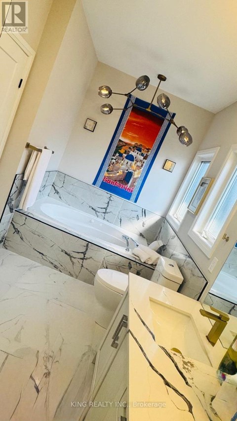 A bathroom with a marble floor and a mirrored wall.