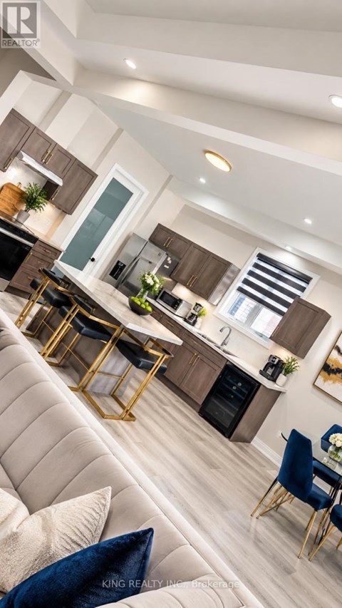A modern kitchen with a dining area and a living room.