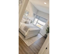 A bedroom with a large bed and a window with blinds.