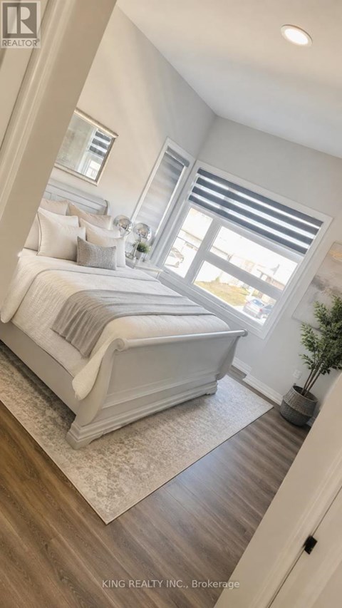 A bedroom with a large bed and a window with blinds.