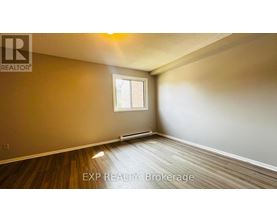 A room with wooden flooring and a window.