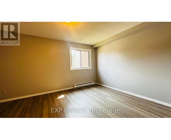 A room with wooden flooring and a window.