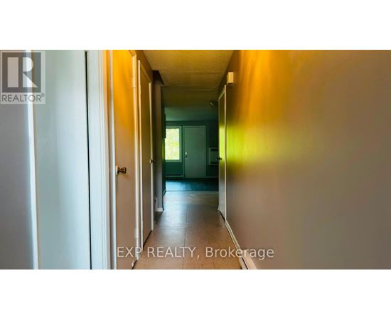 A hallway with a door at the end and EXP REALTY, Brokerage written on the bottom.