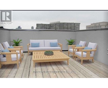 A wooden deck with a sofa, chairs and a table.