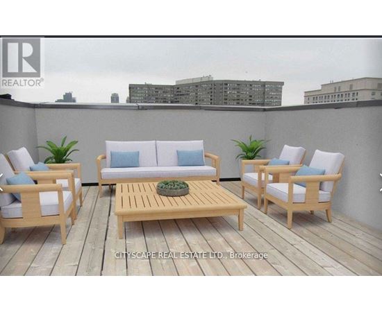 A wooden deck with a sofa, chairs and a table.