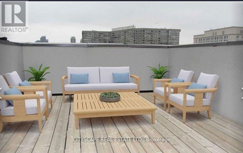 A wooden deck with a sofa, chairs and a table.