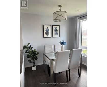 A dining room with a glass table and white chairs.