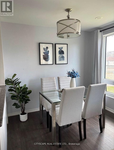 A dining room with a glass table and white chairs.