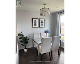 A dining room with a glass table and white chairs.