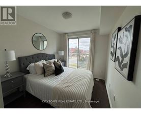 A bedroom with a large bed, a mirror, and a painting on the wall.