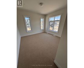 A room with carpet flooring and two windows.