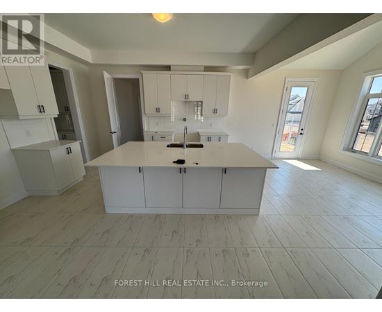 A kitchen with white cabinets and a large island in the middle.