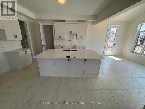 A kitchen with white cabinets and a large island in the middle.