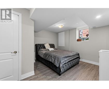 A bedroom with a bed, a window, and a door.