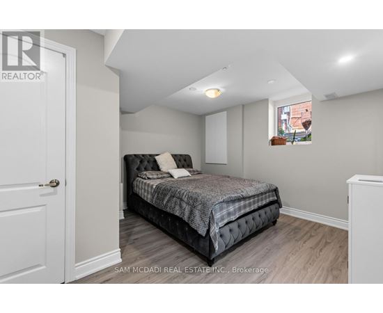 A bedroom with a bed, a window, and a door.