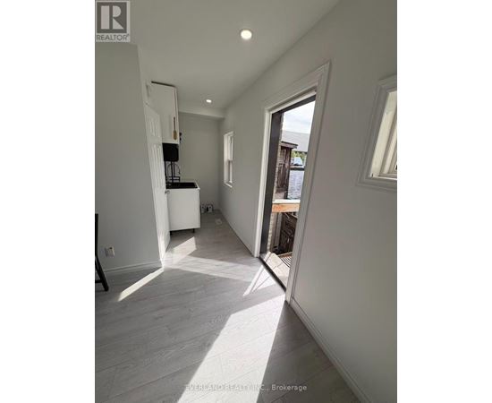 A white interior space with a doorway leading to a balcony.