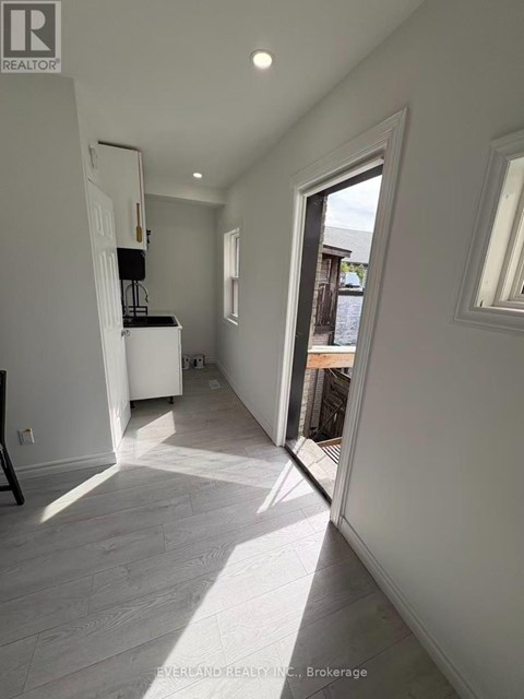 A white interior space with a doorway leading to a balcony.
