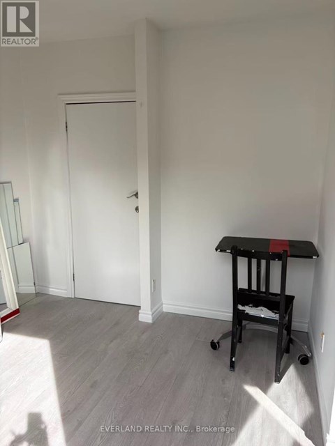 A room with a white door and a black table with wheels.