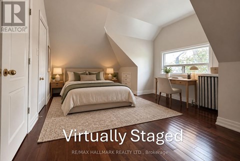 A bedroom with a bed, a chair, and a window.