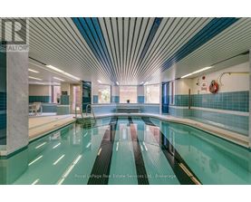 A swimming pool inside a building with a blue tiled wall.