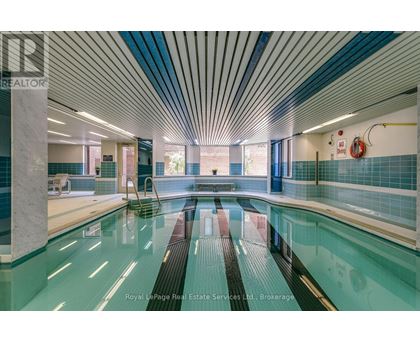 A swimming pool inside a building with a blue tiled wall.