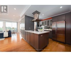 A modern kitchen with dark wood cabinets and stainless steel appliances.