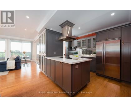 A modern kitchen with dark wood cabinets and stainless steel appliances.