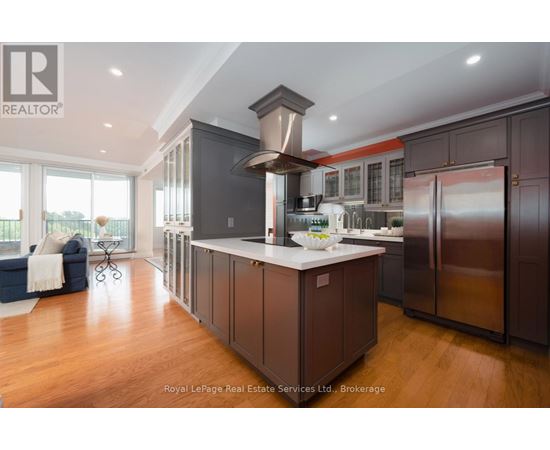 A modern kitchen with dark wood cabinets and stainless steel appliances.