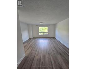 A room with wooden floors and a window letting in light.