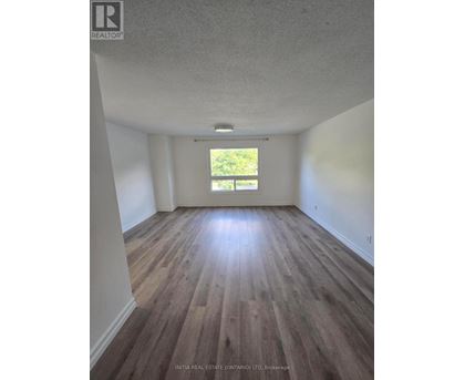 A room with wooden floors and a window letting in light.