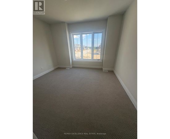 A room with a carpeted floor and a window overlooking a parking lot.