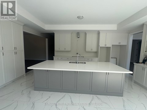 A white kitchen with a marble floor and white cabinets.
