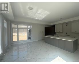 A spacious kitchen with marble flooring and a large island.