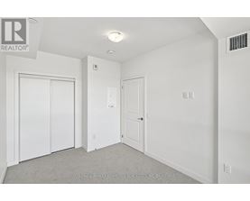 A white bedroom with a door and a window.