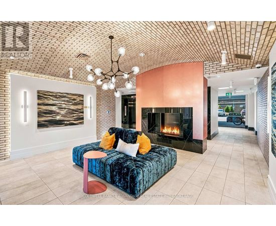 A living room with a blue velvet couch and a fireplace.