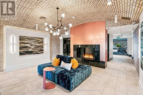 A living room with a blue velvet couch and a fireplace.