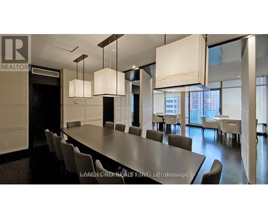 A modern dining room with a long table and chairs.