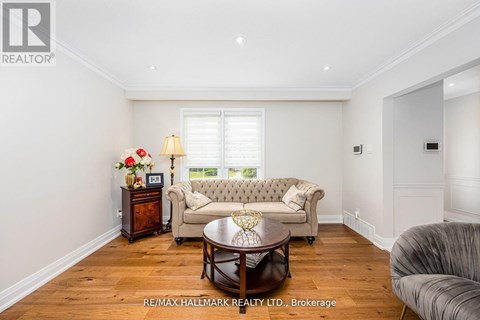 A well-lit living room with a grey sofa and a wooden coffee table.
