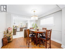 A dining room with a table set for four and a chandelier hanging from the ceiling.