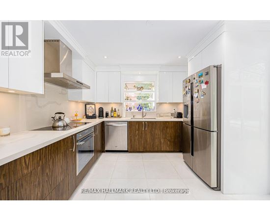 A modern kitchen with white cabinets and a refrigerator.