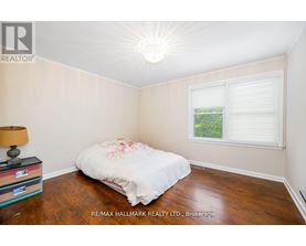 A bedroom with a bed, a lamp, and a window.
