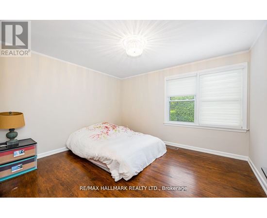 A bedroom with a bed, a lamp, and a window.