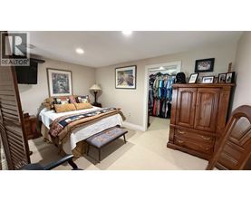 A bedroom with a bed, a chair, and a wardrobe.