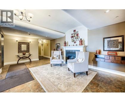 A living room with a fireplace and a rug on the floor.